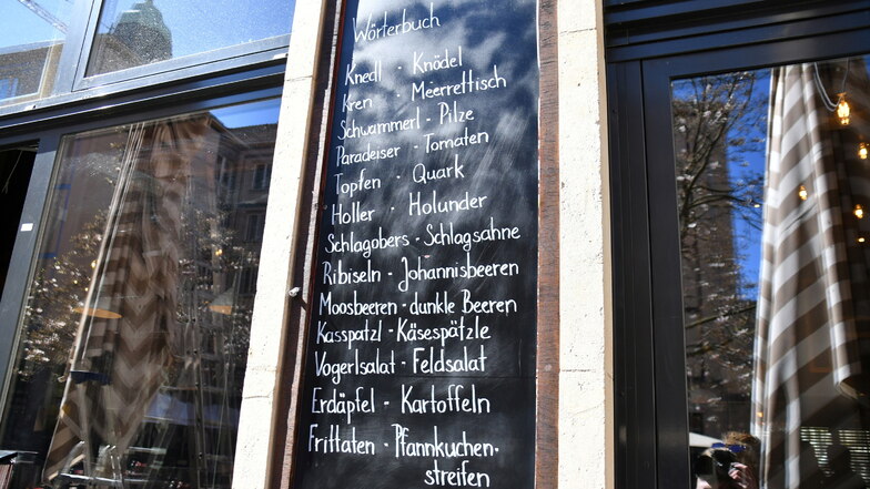 An der Außenwand vom Gasthaus "Almrausch" und in den Speisekarten gibt's eine kleine Hilfestellung in Sachen Sprache.