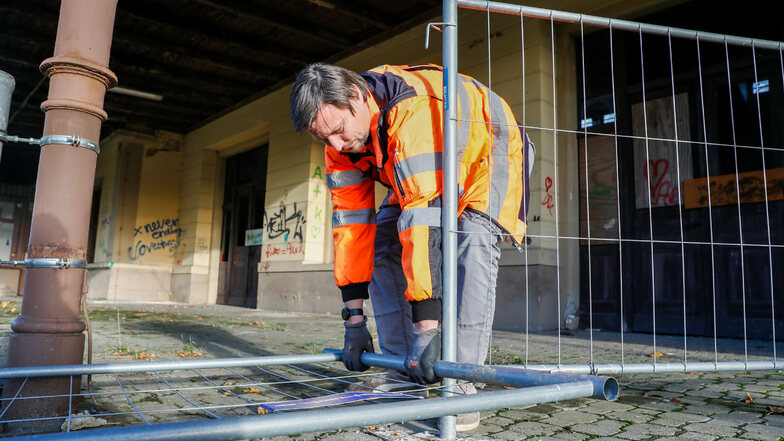 Ronny Däweritz von der DRE richtet einen umgestürzten Bauzaun am Bahnsteig in Seifhennersdorf wieder auf. Er ist umgetreten worden.