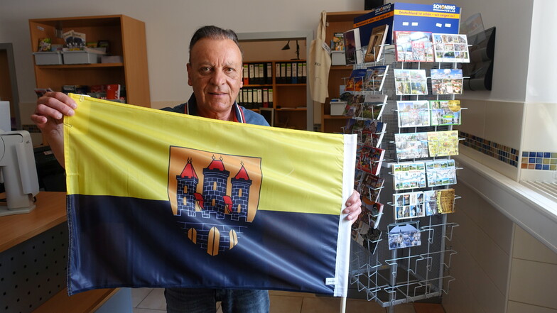 Ulf Fischer mit einer Fahne mit Döbelner Stadtwappen, die es in der Stadtinfo zu kaufen gibt.