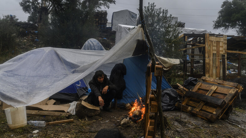 Ein Migrant versucht sich an einem kleinen Feuer in einem provisorischen Lager neben dem Lager Moria auf der Insel Lesbos aufzuwärmen. 