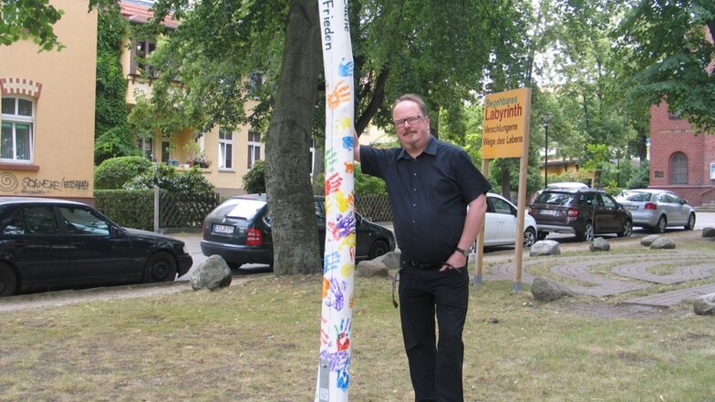 Pfarrer Martin Zinkernagel am Friedenspfahl. Der wurde jetzt zum Gemeindefest gestaltet.