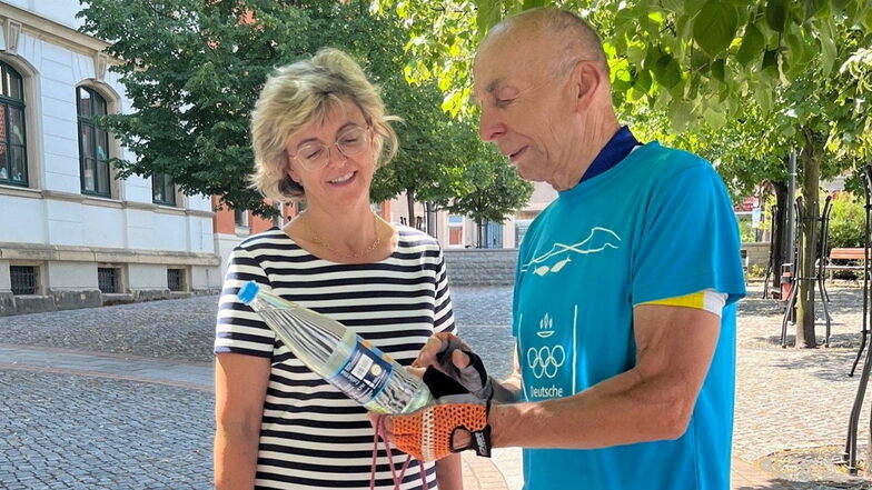 Ortwin Czarnowski (r.) übergibt der Riesaer Bürgermeisterin Kerstin Köhler unter anderem eine Flasche Wasser.
