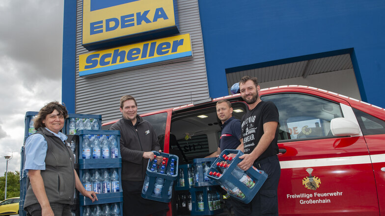 Andrea Giehler und Axel Jakob von Edeka spenden 40 Kisten Wasser an die Großenhainer Feuerwehr, vertreten durch Tom Tschuppan und Christian Tarkotta (v.l.).