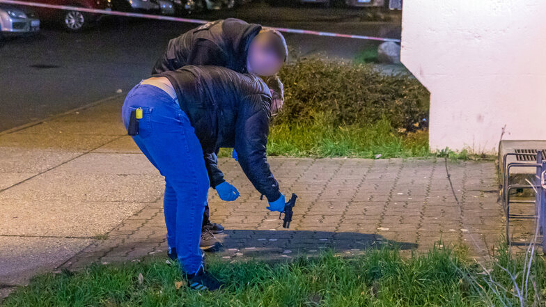 Kriminalbeamte der Polizei stellen vor einem Mehrfamilienhaus in Leipzig eine Waffe sicher, die mutmaßlich im Zusammenhang mit einer Auseinandersetzung steht.