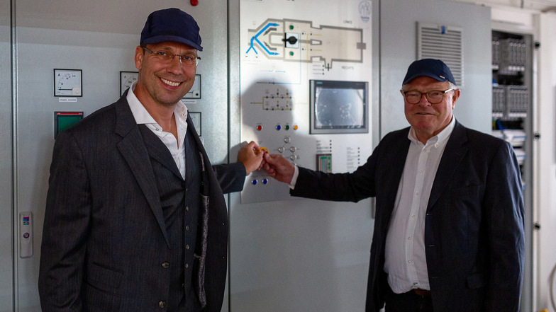 Geschäftsführer unter sich: Göran Grosse (links) und Hans-Bernhard Führ drücken schon mal symbolisch den Knopf zum Start des neuen Ofens in der Glashütte Freital. Am Dienstag wird die Anlage hochgefahren.