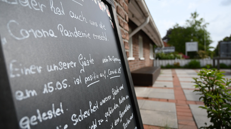 Niedersachsen, Leer: Ein Schild mit der Aufschrift "Leider hat auch uns die Corona Pandemie erreicht."
steht vor dem Restaurant "Alte Scheune". Nach dem Besuch des Lokals sind 23 Gäste positiv auf das Coronavirus getestet worden.