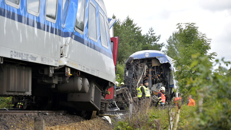 Einsatzkräfte stehen an einem entgleisten Waggon. Ein aus München kommender Expresszug ist in Tschechien mit einem Personenzug zusammengestoßen.