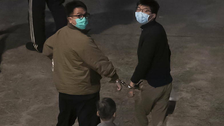 Die Aktivisten Ivan Lam (l) und Joshua Wong wurden mit Handschellen aneinander gekettet.