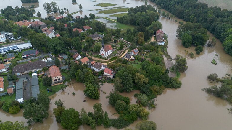 Die Kirche im Görlitzer Stadtteil Görlitz-Weinhübel ragt am Montagvormittag aus der Neiße heraus, die hier auch Grundstücke überschwemmt hat.