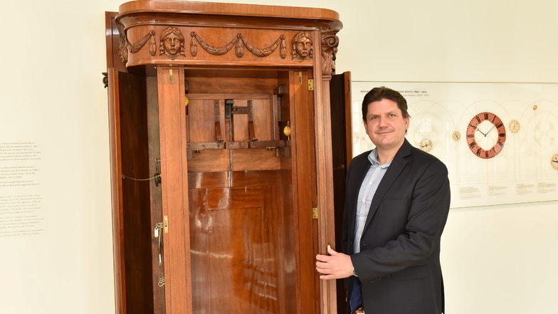 Museumssprecher Michael Hammer steht am leeren Gehäuse der Kunstuhr im Foyer des Uhrenmuseums.