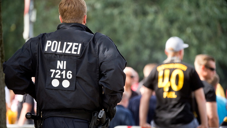 Ein Polizist steht vor einem Fußballspiel zwischen Hannover 96 und Dynamo Dresden in Hannover vor dem Stadium. Die Gewerkschaft der Polizei kritisiert die geplante Kennzeichnungspflicht für Polizeikräfte in geschlossenen Einsätzen.