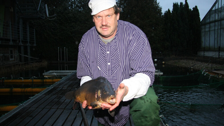 Holger Teuser, der Pulsnitzer Fischgärtner, hält einen Dreipfünder-Karpfen aus eigener Haltung in die Kamera.