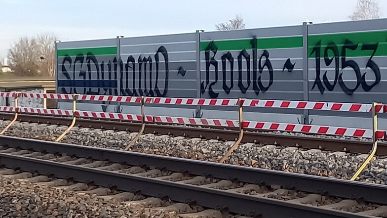 Dieser schwarze Schriftzug steht auf den neuen Lärmschutzwänden an der Bahnstrecke bei Nünchritz.