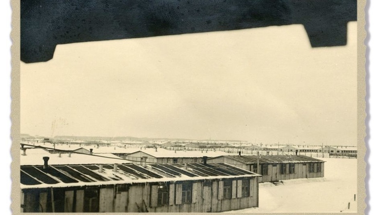 Baracken aus Holz und Stein Ausblick von einem Wachturm am Eingang zur südlichen Lagerstraße im Winter 1941/42: Neben Holzbaracken, die ursprünglich als mobile Unterkunft für Bauarbeiter konstruiert worden waren, sind im Hintergrund Steinbaracken zu sehen