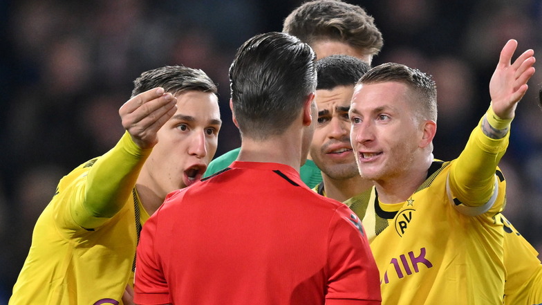 Dortmunder Spieler diskutieren mit Schiedsrichter Danny Makkelie (M) nach der umstrittenen Elfmeterentscheidung.