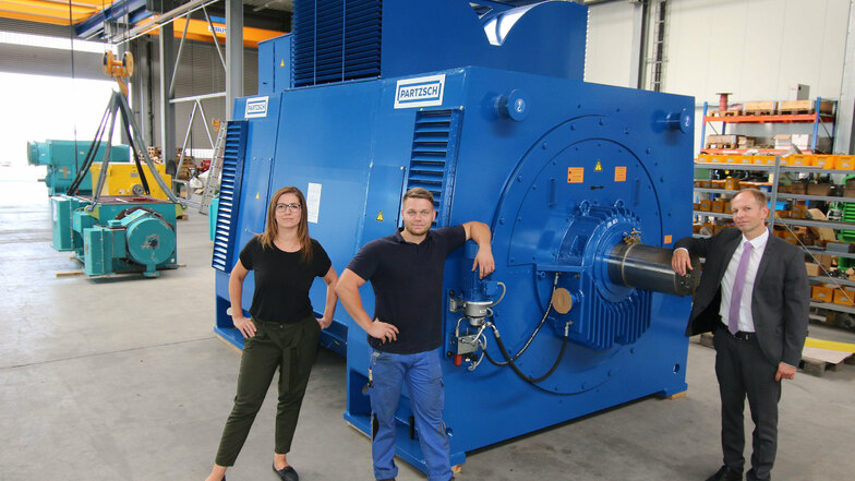Madlen Gabsch (von links), Assistentin der Geschäftsleitung, Mitarbeiter Tom Büttner und Betriebsleiter Thomas Götze stehen an dem Generator, den Partzsch Elektromotoren für eine Papierfabrik gebaut hat. Er ist der erste große Generator, der komplett