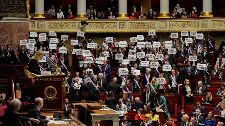 Linksradikale Abgeordnete reagieren mit Papieren, auf denen steht: "64 Jahre. Es ist Nein", in der Nationalversammlung in Paris.