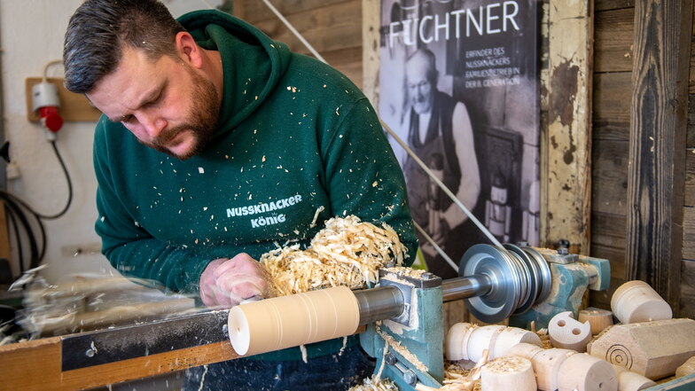 Ein Holzspielzeugmacher drechselt in seiner Werkstatt in Seiffen den Grundkörper für einen Nussknacker.