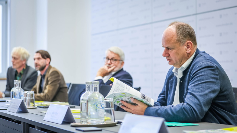 Oberbürgermeister Dirk Hilbert (r.) blättert durch die Machbarkeitsstudie für Dresdens Bewerbung für die Bundesgartenschau.