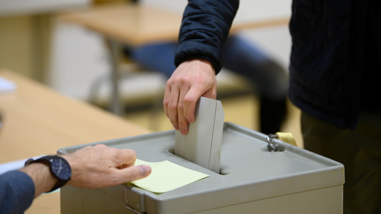 Ein Wähler wirft bei der Stimmabgabe zur Bundestagswahl im Wahllokal seinen Stimmzettel in eine Wahlurne.