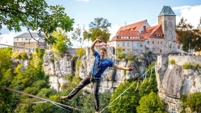 Slackliner Ruben Lagner steht auf einer Highline über dem Bärengarten an der Burg Hohnstein. Hier holte er sich einen neuen Weltrekord.