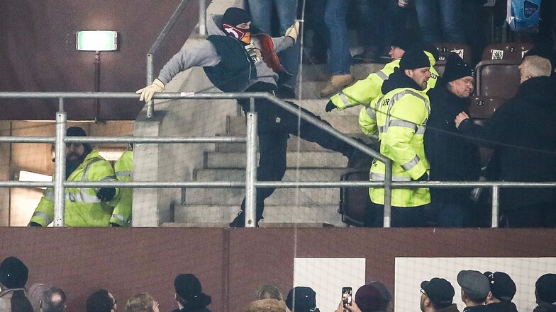 Szenen direkt nach dem Schlusspfiff: Ein gewalttätiger Dynamo-Fan attackiert einen Ordner mit einem Fußtritt.