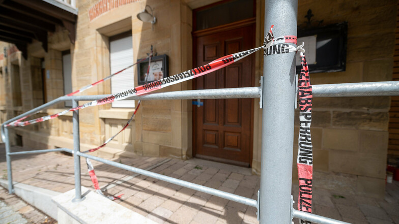 Baden-Württemberg, Rot am See: Absperrbänder der Polizei hängen am Eingang des Hauses, in dem die Tat geschah.