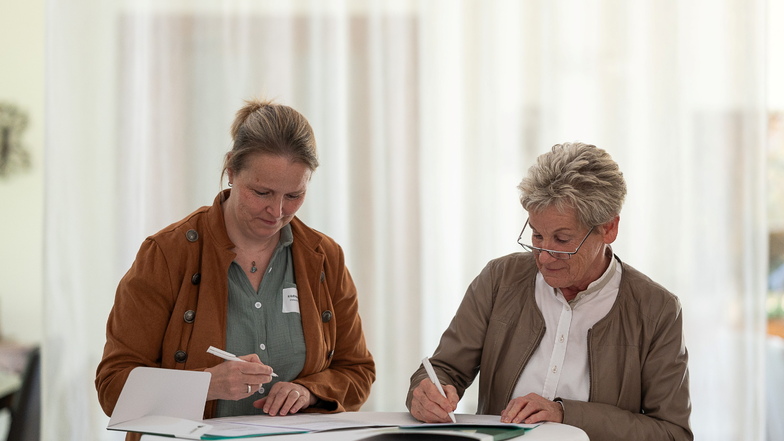 Kristina Milewski, Vorsitzende des Ausbildungsverbundes Pflege,  und Martina Weber, Beigeordnete im Landkreis Görlitz, unterzeichnen die Vereinbarung.