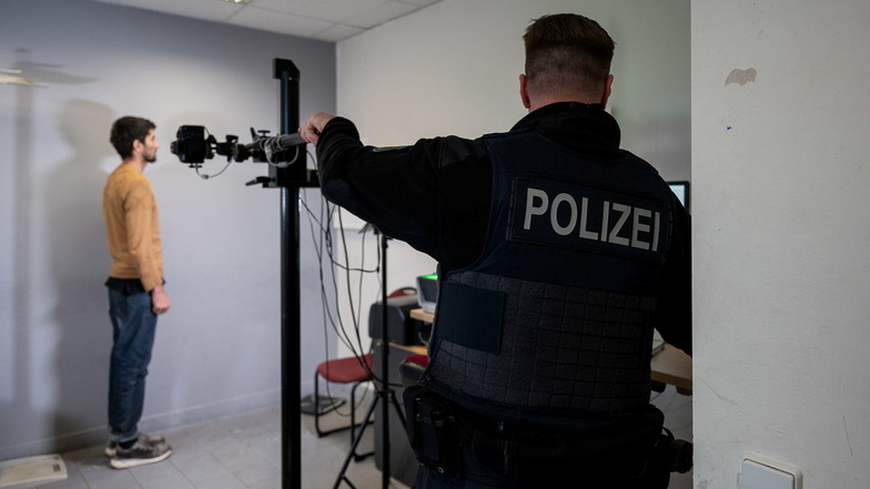 Ein Beamter der Bundespolizei fotografiert einen geflüchteten Mann bei der erkennungsdienstlichen Behandlung an der Grenze zwischen Deutschland und Polen.
