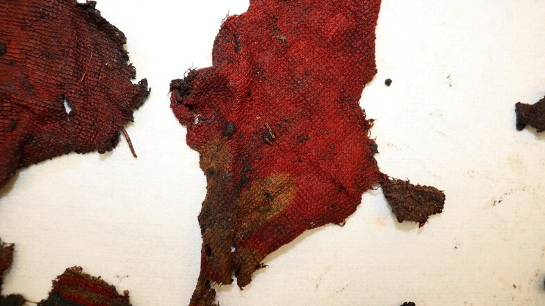 Auch diese roten Stoffreste wurden bei der kleinen Leiche gefunden.