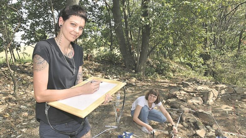 Josefine Mar-Sagi und Hannah Rathschlag (hinten) von der studentischen Arbeitsgruppe dokumentieren hier die Funde an der früheren Hinrichtungsstätte.
