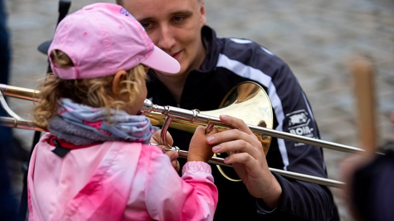 So hält man das Instrument: Ein Mitglied vom Spielmannszug Oberlichtenau zeigt einem Kind, auf was es achten sollte.