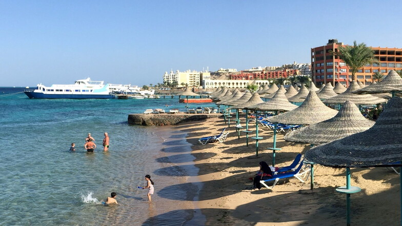 Touristen stehen in Hurghada an einem Hotel-Strand.