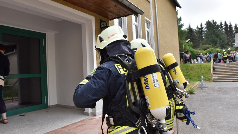 Unter Atemschutz betreten die alarmierten Feuerwehrleute am Freitag die Oberschule in Geising.