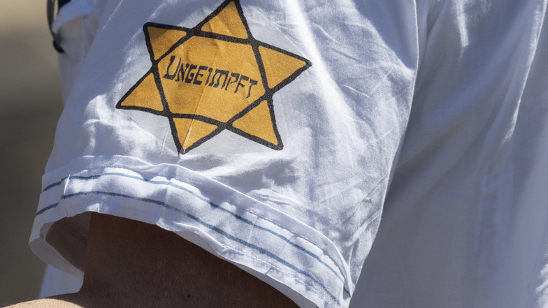 "Ungeimpft" steht auf einem nachgebildeten Judenstern am Arm eines Mannes, der versucht hatte, sich unter die Teilnehmer einer Demonstration zu mischen, die sich auch gegen Verschwörungstheorien zum Corona-Virus wendet.