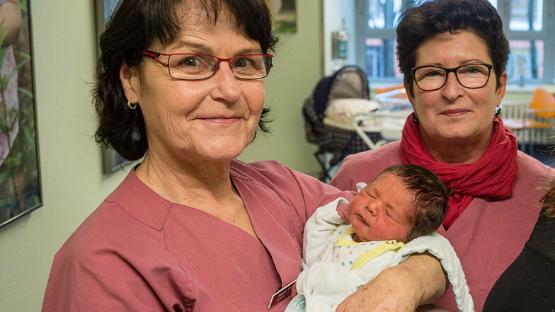 Eins von Tausenden: Regine Werwoll (links) mit einem Neugeborenen im Arm. Rechts: Kristina Winkler, leitende Oberärztin der Frauenklinik.