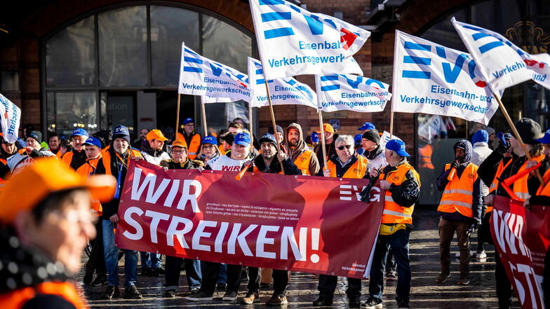 Demonstranten der Eisenbahn- und Verkehrsgewerkschaft stehen mit Plakaten vor dem Hauptbahnhof in Bremen.