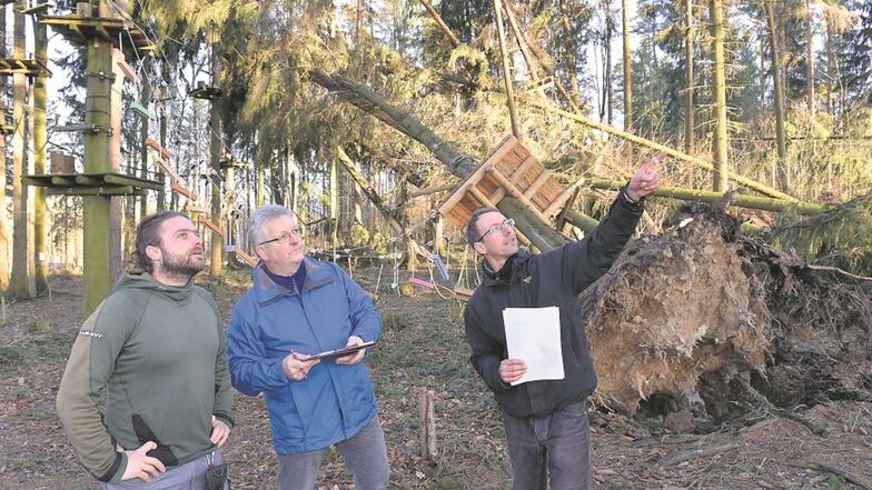 Die Inhaber des Kletterparks Sherwood Forest Danny Schubert (li.) und Renè Petzold (re.) sehen sich mit Versicherungsgutachter Olaf Wache die Sturmschäden im Parkgelände in Paulsdorf an.