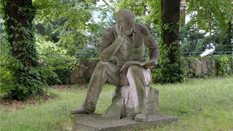 Die Skulptur „Lesender Bauernstudent“ stammt von Georg Türke und steht seit 1960 im Park des St.Afra Gymnasiums.