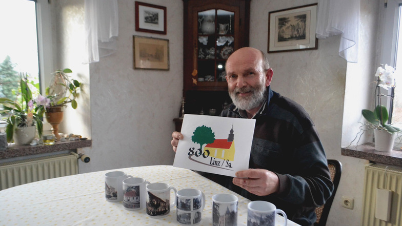Der Linzer Ortschronist Frank Schneider mit Tassen-Kollektion und Logo zum 800-jährigen Dorfjubiläum.