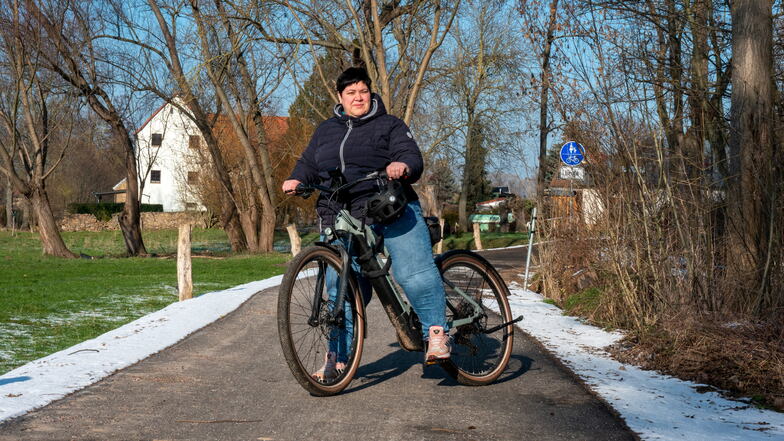 Katja Töpfer von der Gemeindeverwaltung Jahnatal fährt mit ihrem Job-Rad von Pulsitz nach Ostrau auf Arbeit. Sie ist froh, dass die Sanierung des Jahnatalweges abgeschlossen ist.