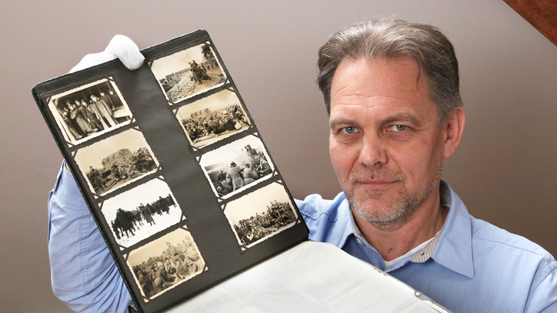 Der Zeithainer Gedenkstätten-Leiter Jens Nagel zeigt ein Album mit Fotos aus dem hiesigen Kriegsgefangenenlager.