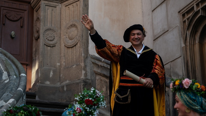 Octavian Ursu, Oberbürgermeister der Stadt Görlitz winkt dem Publikum auf der Rathaustreppe am Untermarkt zum Start der Prozession zur Altstadtbrücke.