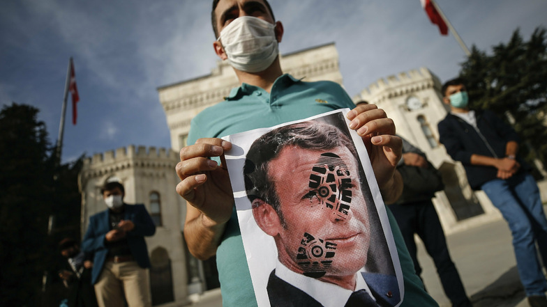 Ein junger Mann in Istanbul hält ein mit einem Schuhabdruck versehenes Foto von Emmanuel Macron, Präsident von Frankreich, in die Kamera. Recep Tayyip Erdogan, Präsident der Türkei, griff Macron ein zweites Mal verbal an und warf ihm Islamfeindlichkeit vo