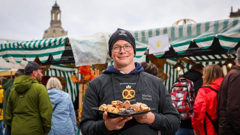 Bäcker Marlon Gnauck beim Brotmarkt auf dem Altmarkt in Dresden. Im Hintergrund ist die Sonne zu sehen, welche ihm ein Mädchen malte.