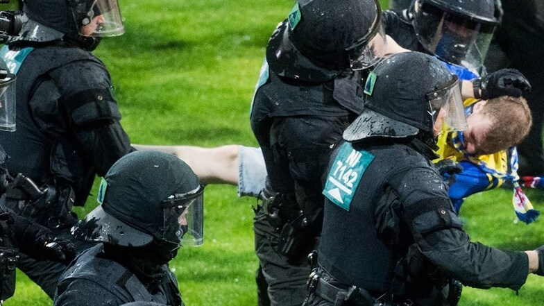 Auf dem Spielfeld mussten Polizisten den VfL-Fanblock vor den Eintracht-Anhängern schützen.