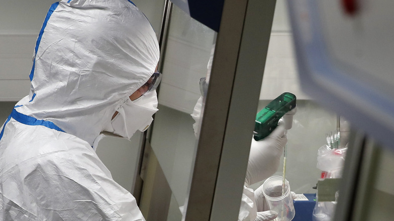 Ein Laborwissenschaftler in Schutzkleidung arbeitet im Institut Pasteur mit Proben von Patienten, die mit dem Coronavirus infiziert sind.