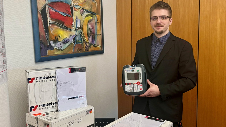 Benjamin Pätzold von der Sparkasse zeigt einen der Defibrillatoren.
