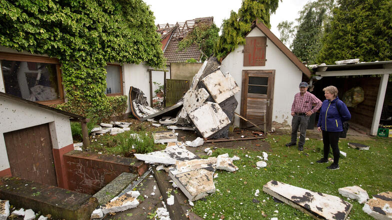 Nach einer Windhose in Minden in Nordrhein-Westfalen stehen 23. Mai 2016 Hausbesitzer in ihrem Garten im Stadtteil Meißen, in dem Teile eines schwer beschädigten Hauses liegen (Symbolfoto).