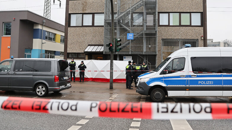Polizisten stehen vor dem Gebäude der Zeugen Jehovas im Stadtteil Alsterdorf. Bei Schüssen in einer Veranstaltung der Zeugen Jehovas sind am Donnerstagabend mehrere Menschen getötet und einige Personen verletzt worden.